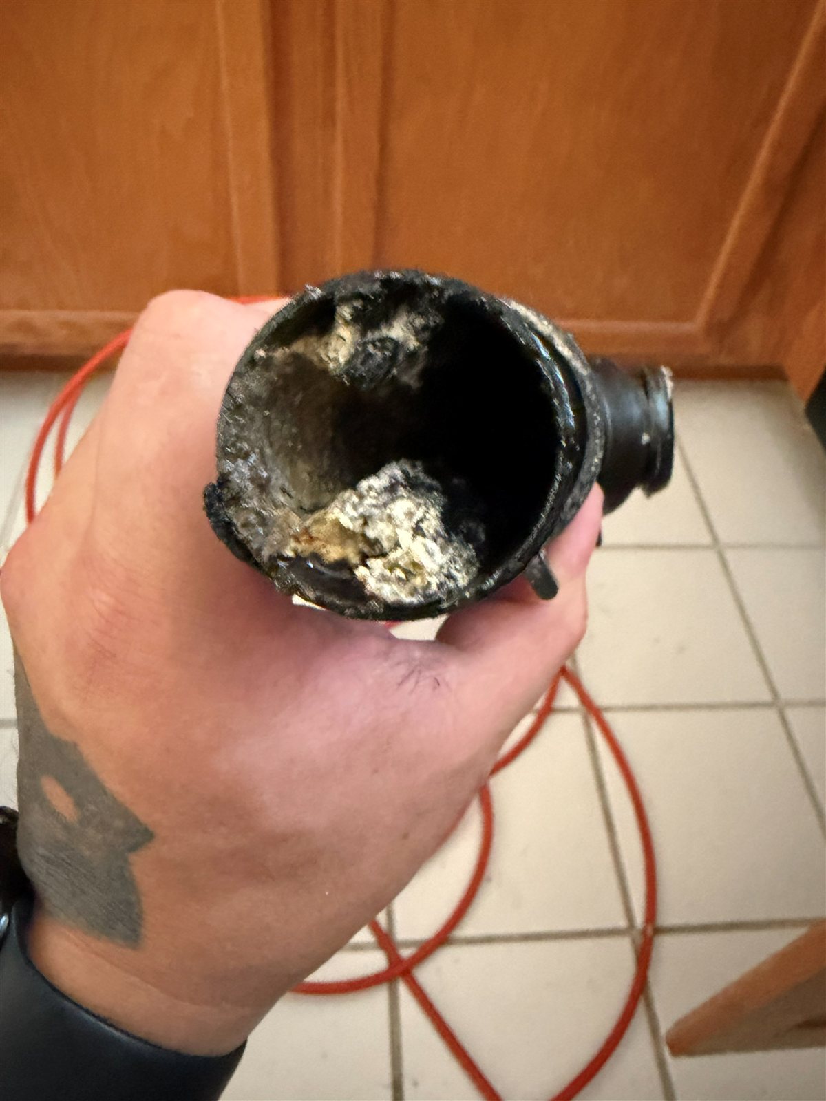 Pipe fitting removed showing years of mineral scale and debris buildup before hydrojetting